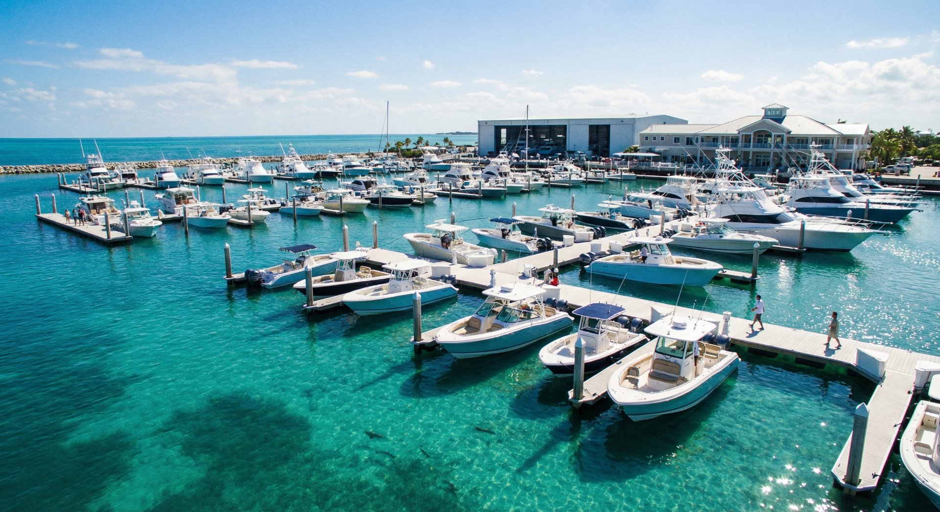 Boats docked at a marina with clear blue water