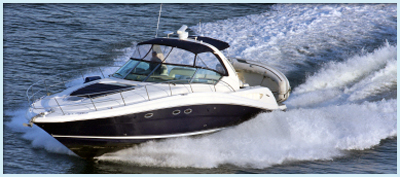 Motor yacht with a dark blue hull and white superstructure cruising at speed across open water.