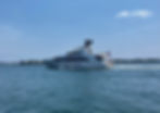 Large white motor yacht cruising on open water, photographed from a distance.