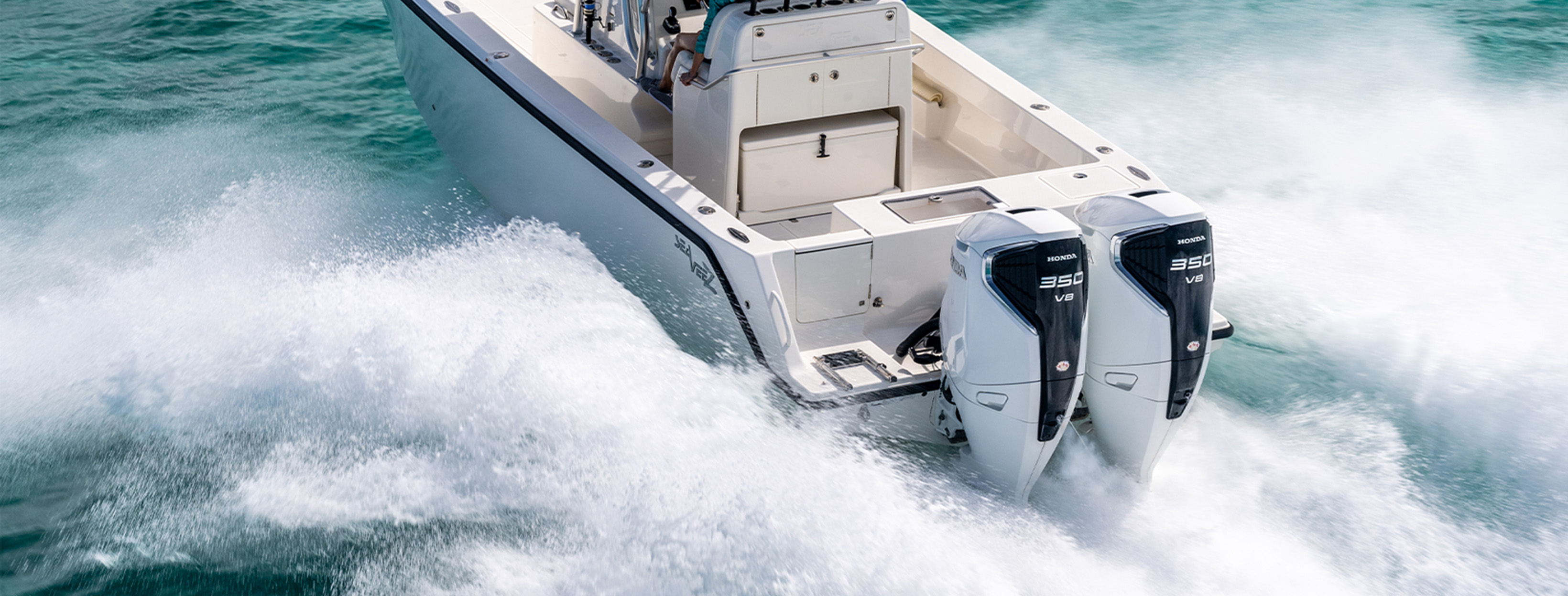 White center console boat with twin Honda 350 V8 outboard engines running at speed across turquoise water.