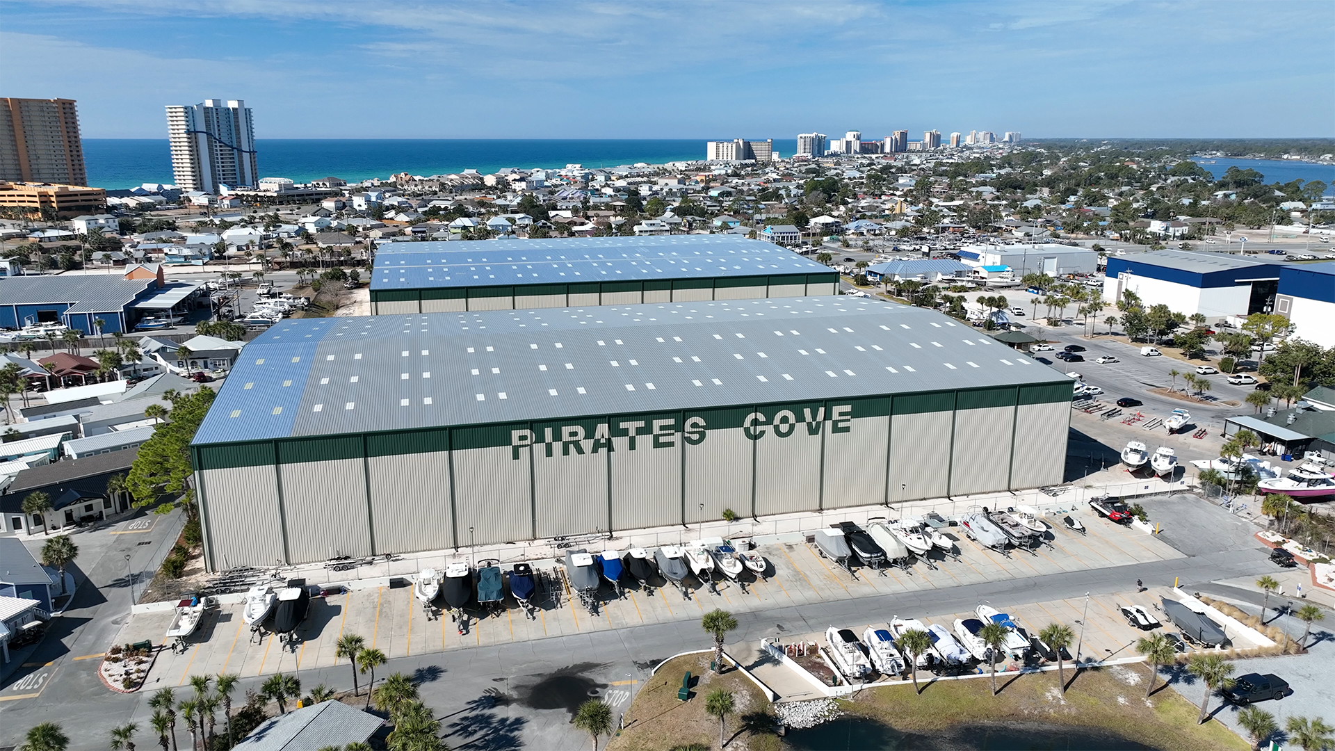 Aerial view of Pirates Cove boat storage buildings with boats lined up outside, overlooking the Gulf coast in Panama City Beach.
