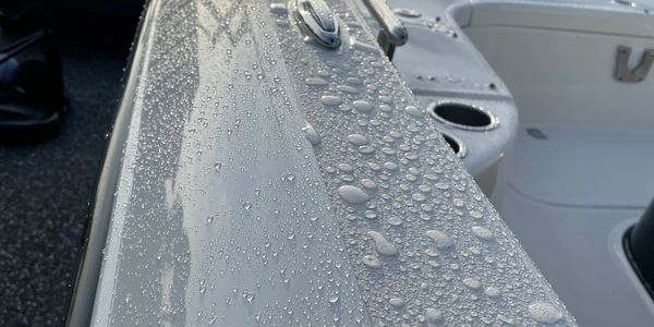 Water beading on the white gunwale of a boat, showing a clean, hydrophobic finish.