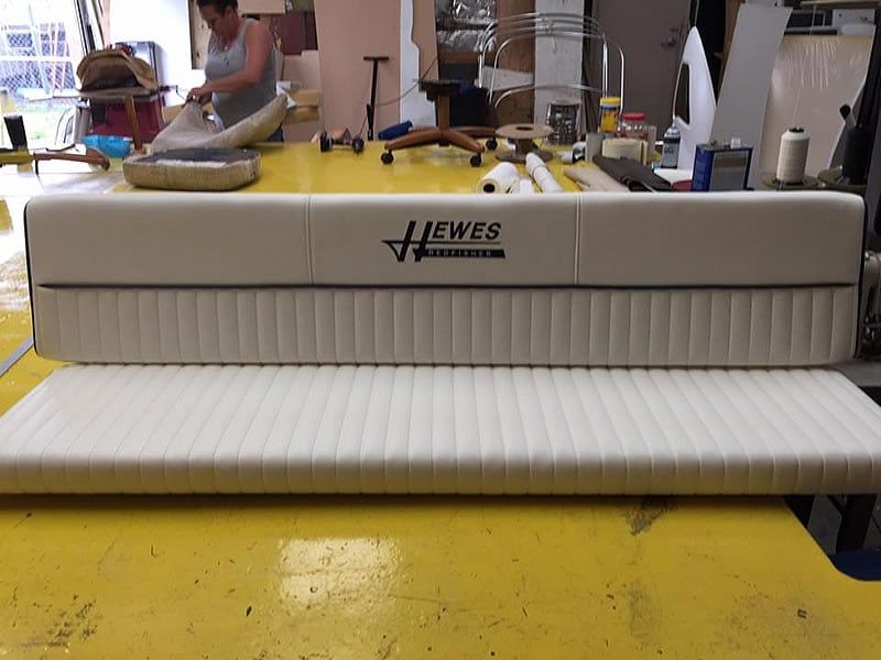 White pleated vinyl boat bench seat being upholstered at Hewes Refinisher.