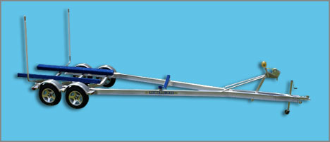 Aluminum boat trailer with blue bunk supports and twin wheels, shown against a blue backdrop.