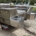 Grey boat hull resting on a trailer outdoors, with no business name or town visible.