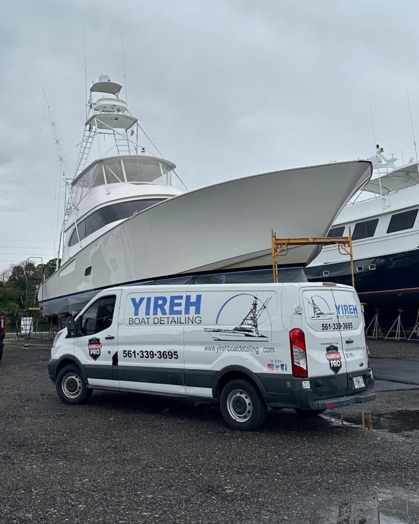 White sportfishing yacht on stands beside a Yireh Boat Detailing van at the boatyard.
