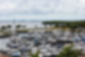 Marina with many moored sailboats and motorboats along the waterfront.