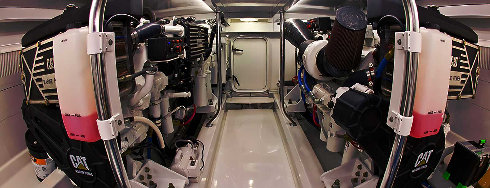 Twin Cat Marine Power diesel engines in a boat engine room, showing coolant reservoirs, air intakes and plumbing.