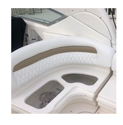 Quilted tan and white upholstered seating panel on a boat interior, with no business name or town visible.