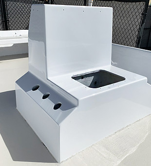 White fiberglass deck console with a recessed hatch and three fittings on a boat deck.