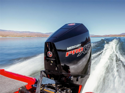 Mercury Pro XS outboard motor mounted on a boat cruising across a lake with a wake behind it.