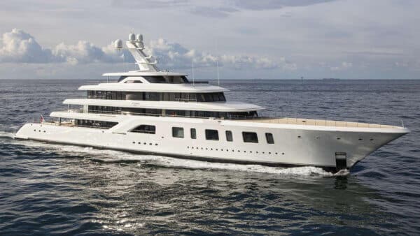 Large white motor yacht with a multi-deck superstructure and radar arch cruising across open water.