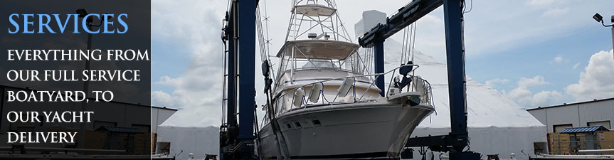 White motor yacht hoisted by a blue travel lift at a boatyard with a service banner overlay.
