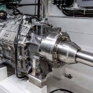 Marine reverse-gear transmission with propeller shaft coupling mounted on a test stand, with Volvo Penta engine components visible in the background.