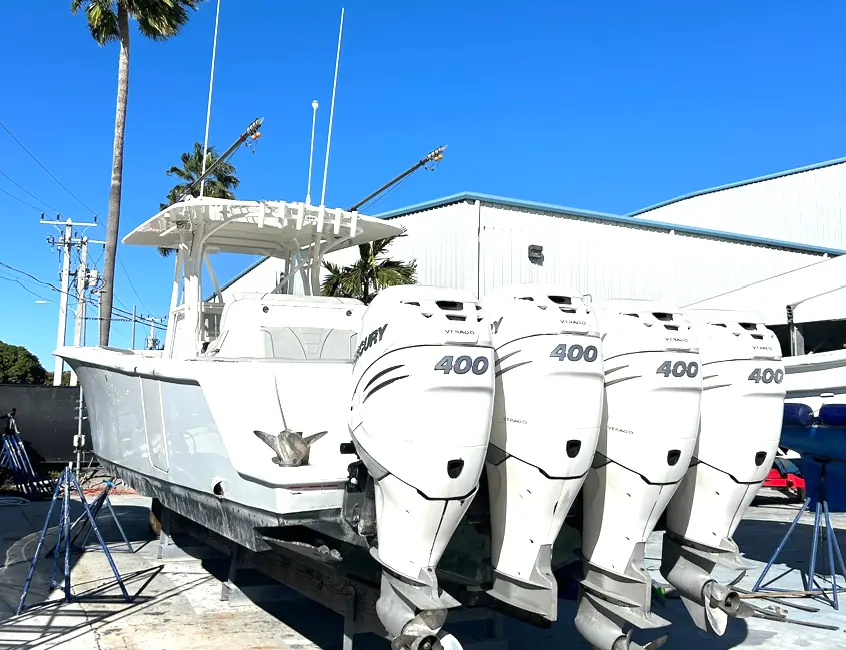 Center console sportfishing boat with four Mercury 400 outboards displayed at a boatyard in Florida.