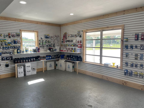 Interior of a marine parts and supplies store with oil containers, fittings, and accessories displayed on slatwall shelving.