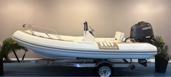 Novuraiia-branded inflatable rigid-hull boat with a Yamaha outboard motor on a trailer in a showroom.