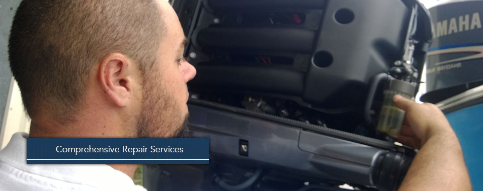 Technician inspecting the engine cowling of a Yamaha outboard motor during a comprehensive repair service.