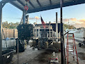 Work vessel in a boatyard with a metal ladder and scaffolding beside it.