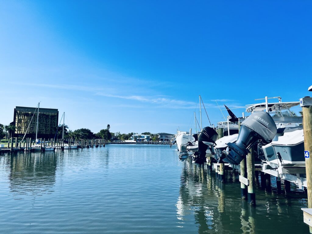 Yamaha outboard motor boats moored at a dock along a calm waterway with a waterfront building in the distance.