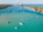 Aerial view of boats on a turquoise waterway with a distant shoreline, not tied to a specific business or town.