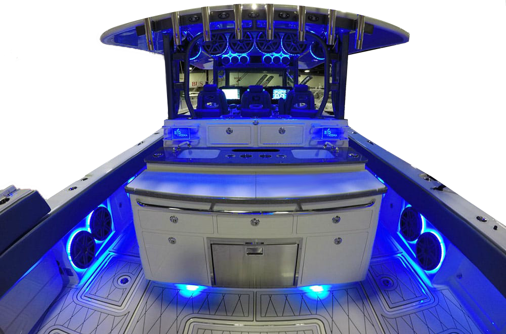 Center console boat helm and cockpit with blue LED lighting and custom audio speakers, shown as a boat interior photo.