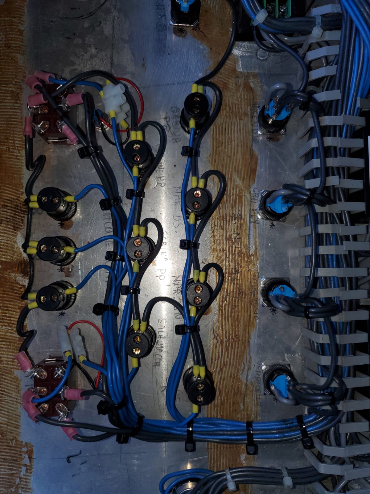 Marine electrical panel wiring with labeled switches and crimped connectors, photographed inside an unidentified vessel.