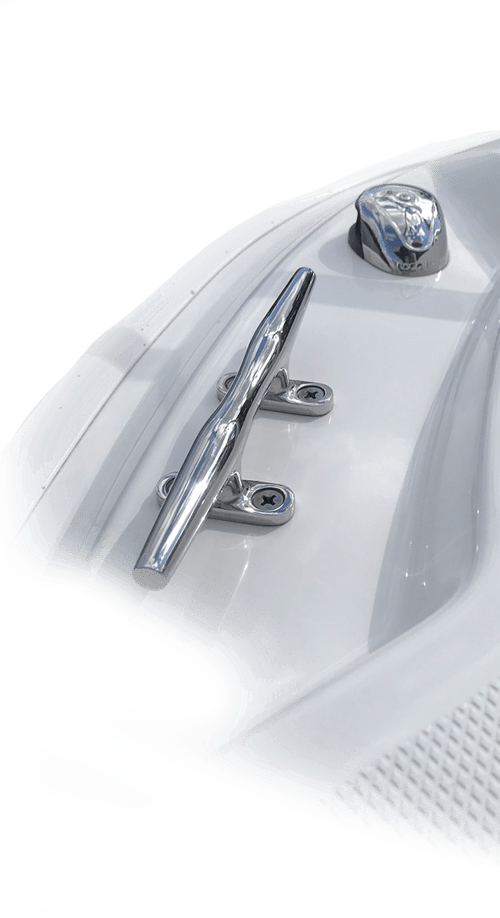 Polished chrome dock cleat and winch mounted on the white fiberglass deck of a boat.