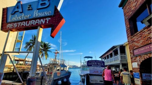 Waterfront view of docked boats and the A & B Lobster House sign at Historic Seaport Harbor Walk, Key West.