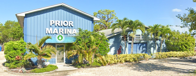 Front facade of Prior Marina with blue siding and palm landscaping, Prior Marina, Palm Harbor.