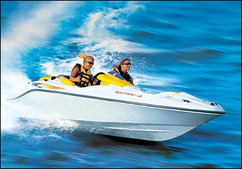 Two riders in life vests speeding across open water on a white and yellow personal watercraft.