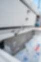 Blurred close-up of a white boat surface with metal hardware, location unknown.